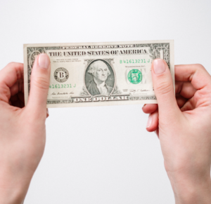 A person holding a one dollar bill with both hands against a plain white background.