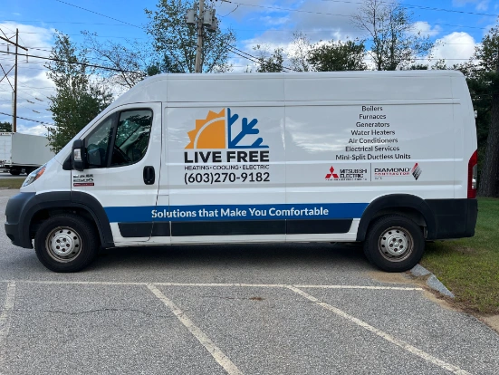 White van featuring "Live Free Heating-Cooling-Electric" branding, contact number, and a list of services offered—parked on a paved road beside grass and trees, showcasing our about us story in every detail.